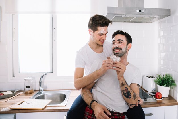 Gentle loving men with cookie in kitchen