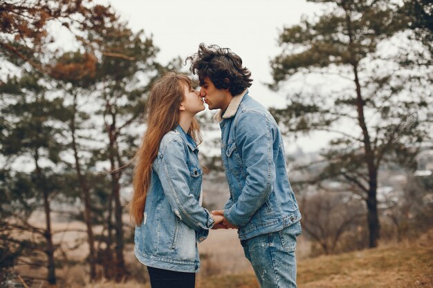 gentle and stylish couple are having a walk in the autumn park