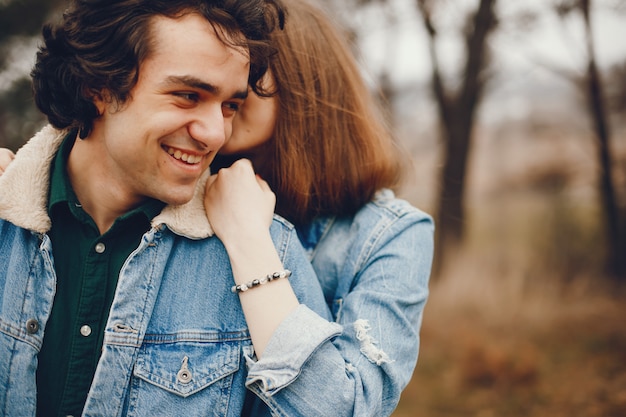 Gentle and stylish couple are having a walk in the autumn park