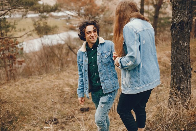 gentle and stylish couple are having a walk in the autumn park