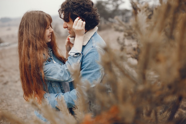 gentle and stylish couple are having a walk in the autumn park