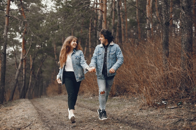 gentle and stylish couple are having a walk in the autumn park