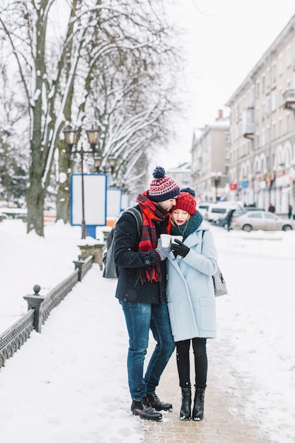 Нежные молодые люди, обнимающиеся в зимнем городе