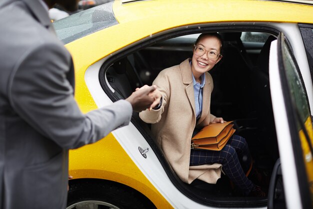 Gentleman Helping Young Woman Leave Taxi