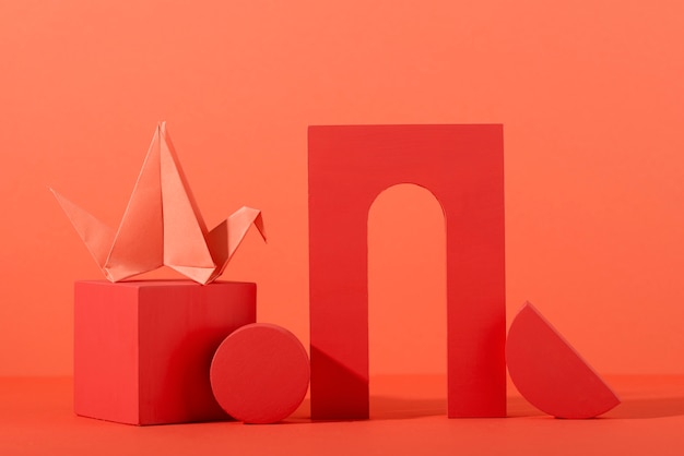 Geometric paper shapes on coral background