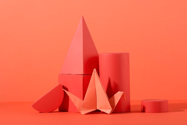 Geometric paper shapes on coral background