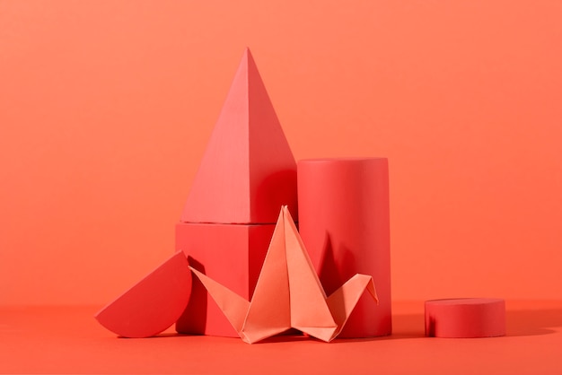 Geometric paper shapes on coral background