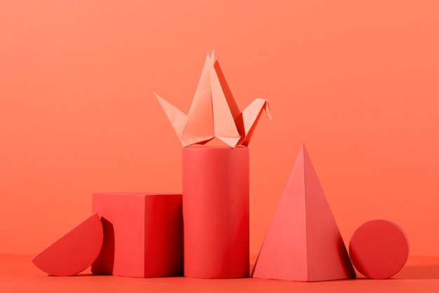 Geometric paper shapes on coral background