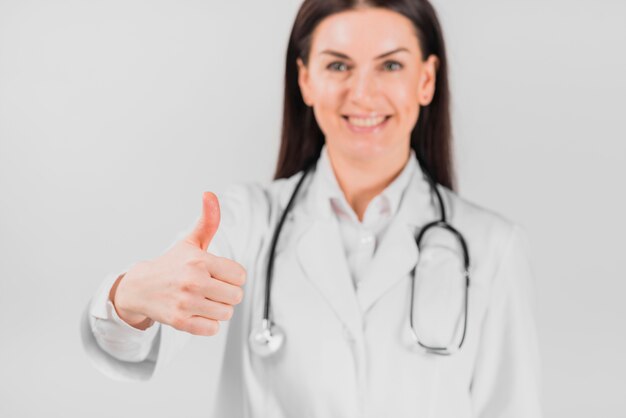 Gesture thumbs up of doctor woman 