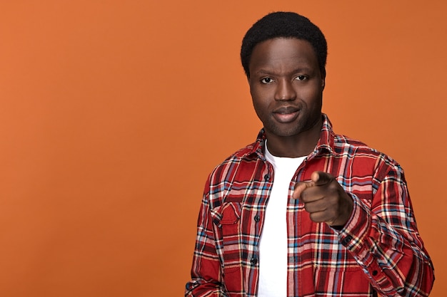 Get ready! Fashionable attractive young Afro American guy having positive confident facial expression and pointing index finger. Signs, gestures, symbols and body language