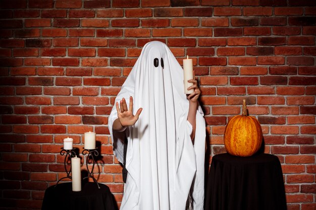 Ghost holding candle at Halloween party