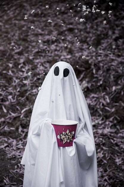 Ghost holding popcorn box with popcorn in air 