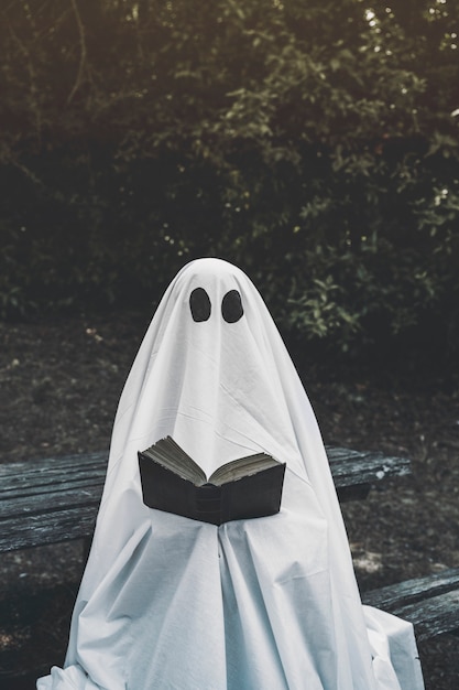 Ghost sitting on bench and reading book 