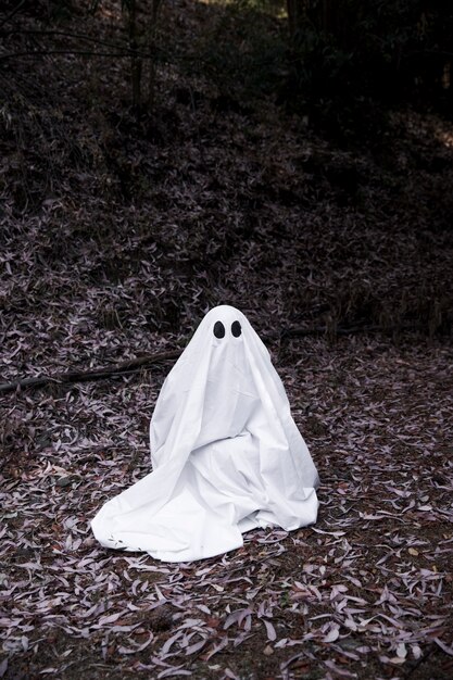 Ghost sitting on soil in forest 