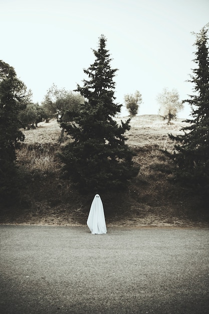 Ghost standing on asphalt road