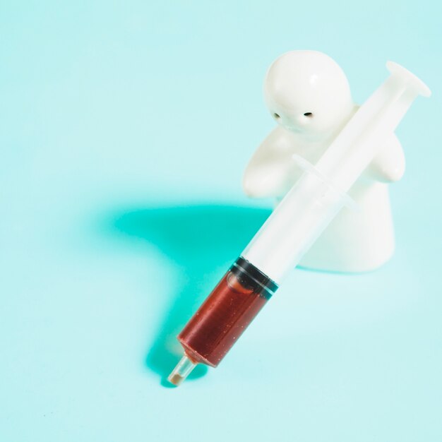 Ghost statuette holding syringe with liquid