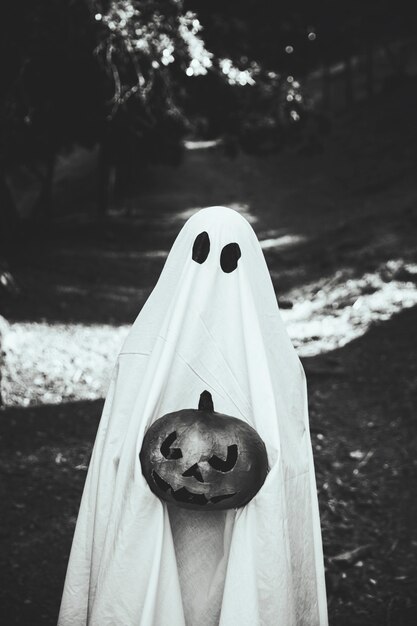 Ghost with devil pumpkin in hands 