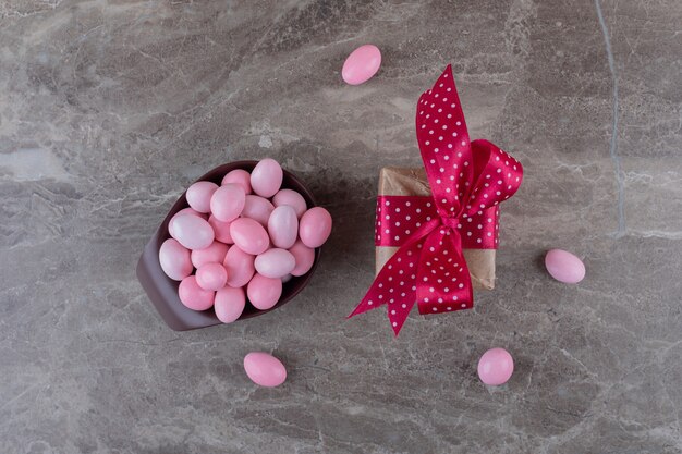 Gift box and a bowl of chewing gum on the marble surface