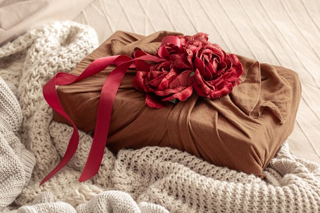 Gift box decorated with ribbons and decorative roses on knitted items. Original gift wrapping for valentine's day.