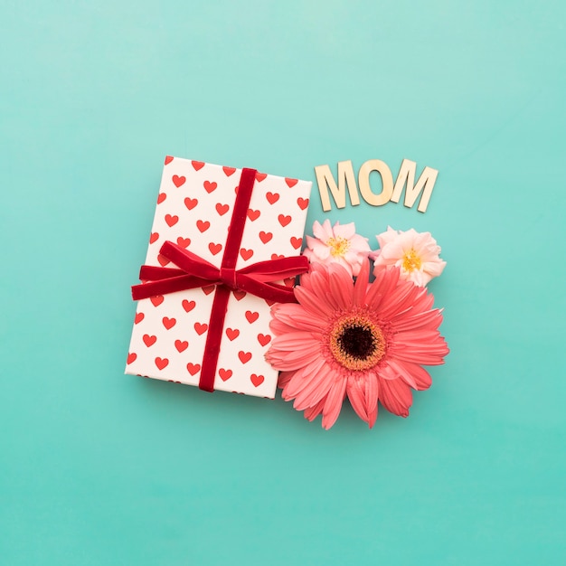 Подарочная коробка, цветы и надпись «мама» крупным планом