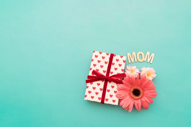 Подарочная коробка, цветы и надпись «мама»