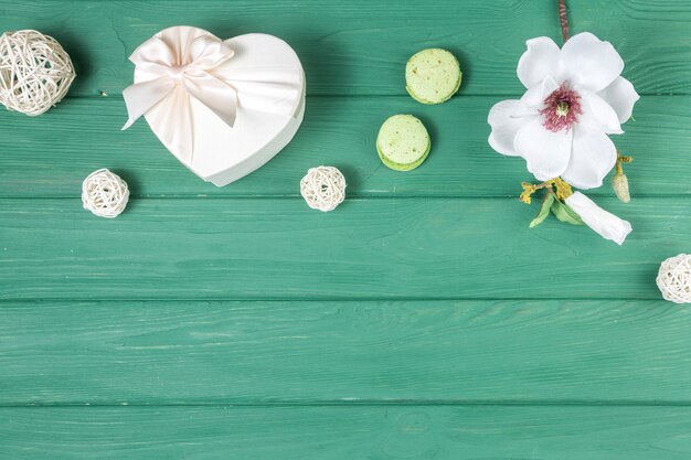 Gift box in heart shape with flower and macaroons