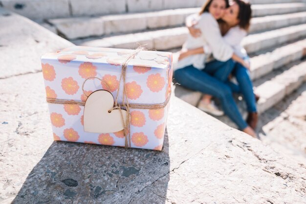 Gift box near hugging women