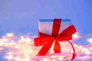 Free photo gift box in neon lighting with a garland