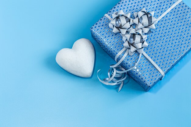 Gift box Packed in blue paper on a blue background .