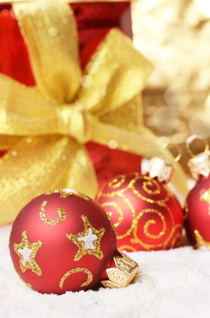 Gift box and red christmas balls in the snow