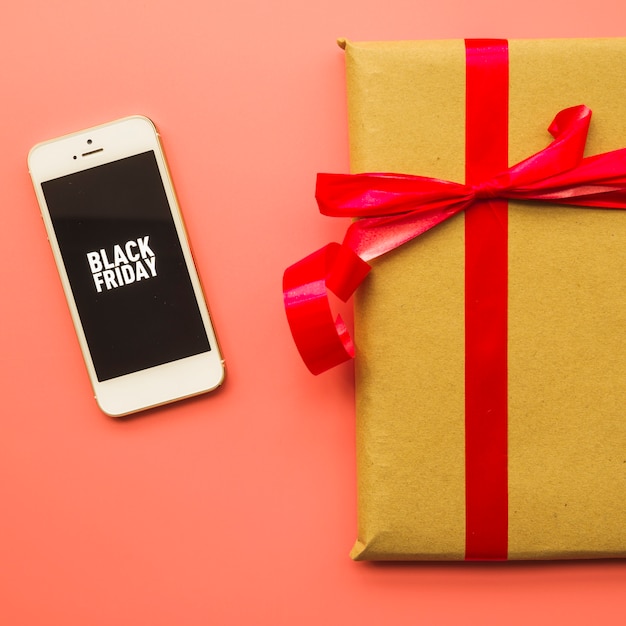 Foto gratuita confezione regalo con scritta black friday sul telefono