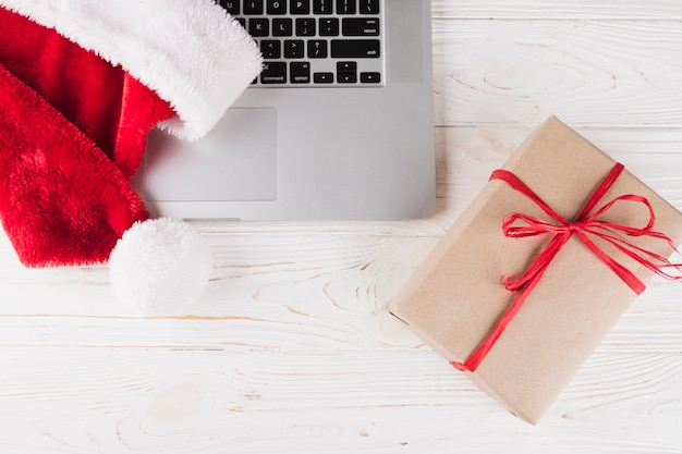 Gift box with laptop on wooden table