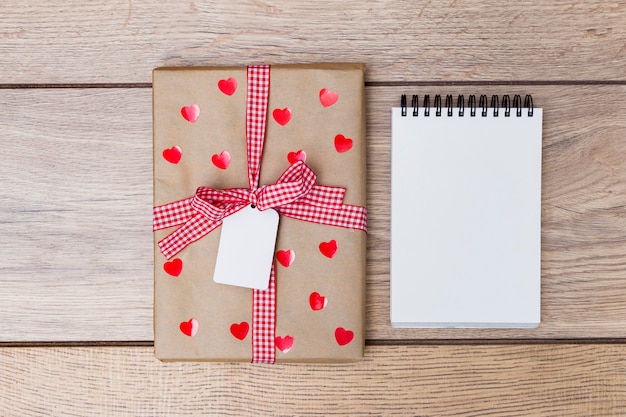 Gift box with notepad on table 