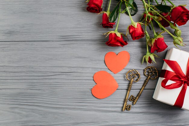 Gift box with paper hearts on grey table