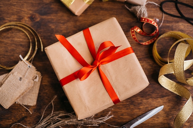 Gift box with red ribbon on table