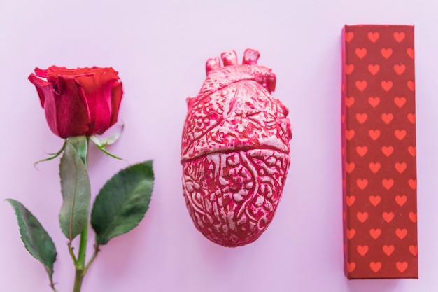 Бесплатное фото Подарочная коробка с красной розой на столе