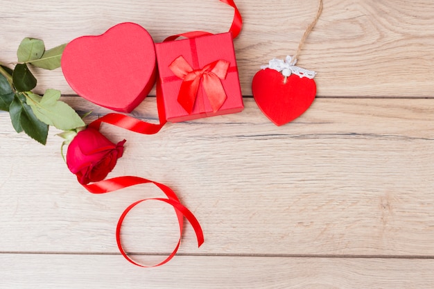 Gift box with red rose on table 