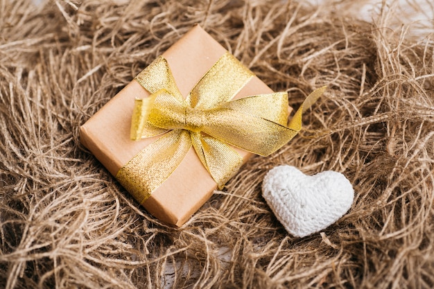 Gift box with small soft heart on table