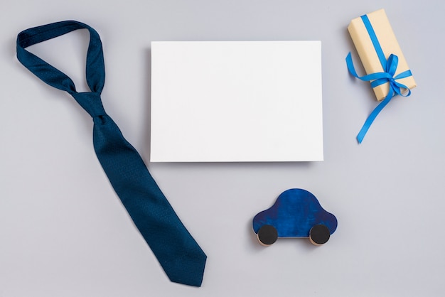 Gift box with toy car, paper and tie