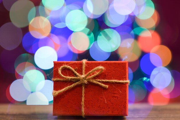 Gift box on wooden board with bokeh in the background