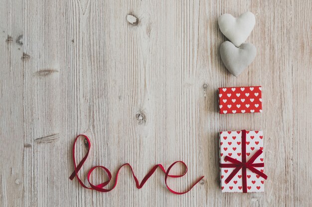선물 상자, 두 개의 하트와 나무 테이블에 단어 "사랑"