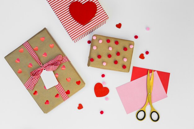 Gift boxes with paper hearts on table