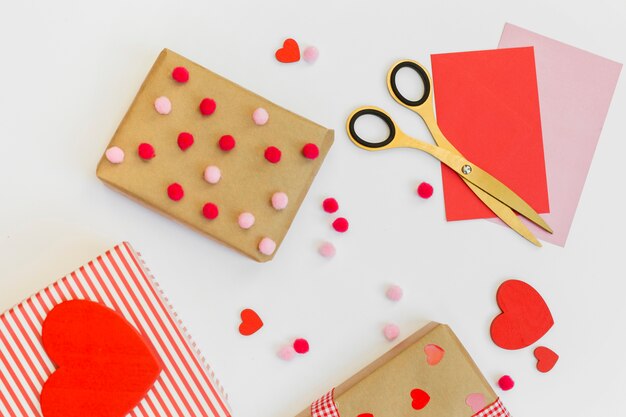 Подарочные коробки с красными сердцами и конверты на столе