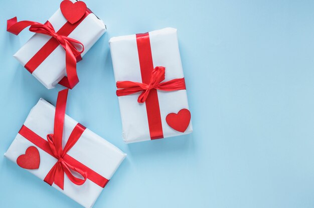 Gift boxes with red hearts on table