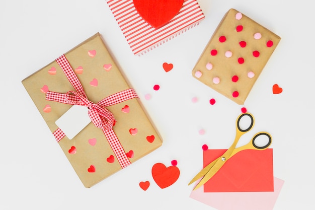 Gift boxes with small red hearts on table