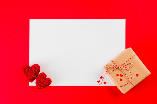 Подарочные и вязаные сердечки на бумажном листе