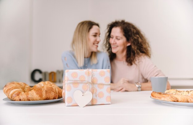 Foto gratuita regalo vicino a madre e figlia sfocate