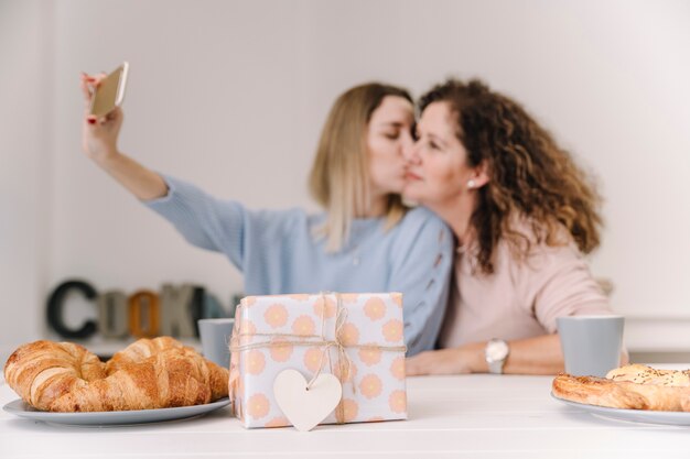 Gift near women posing for selfie