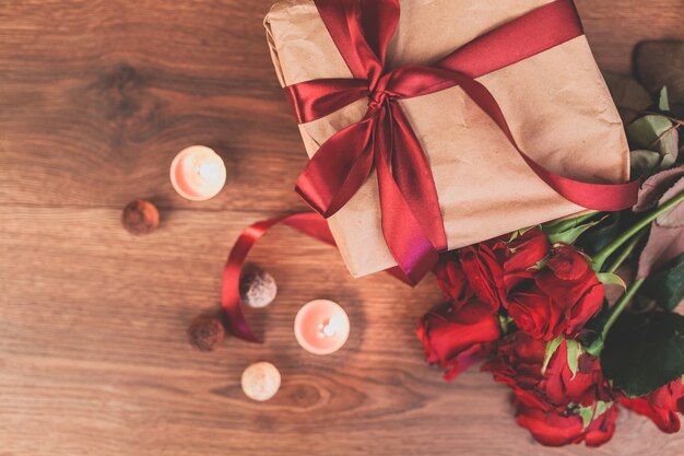 Gift with lighted candles and roses seen from above