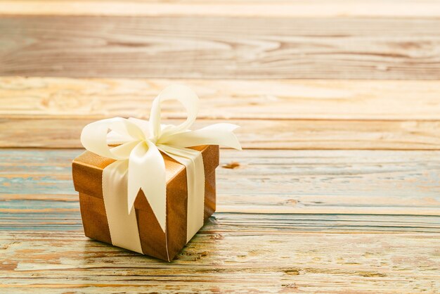 Gift with a white bow on a wooden table